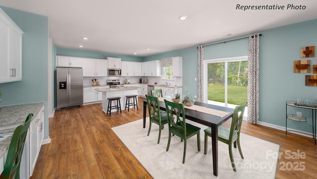 dining area featuring wood finished floors, recessed lighting, and baseboards