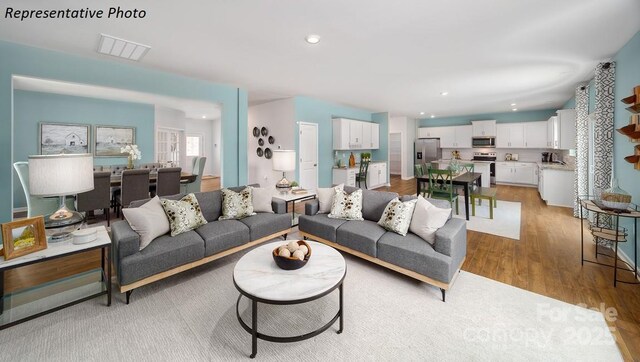 living area featuring recessed lighting, visible vents, and light wood-style floors
