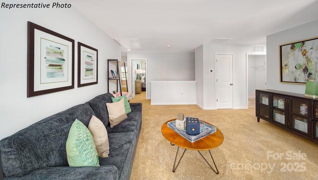 living area with baseboards, visible vents, attic access, and carpet flooring