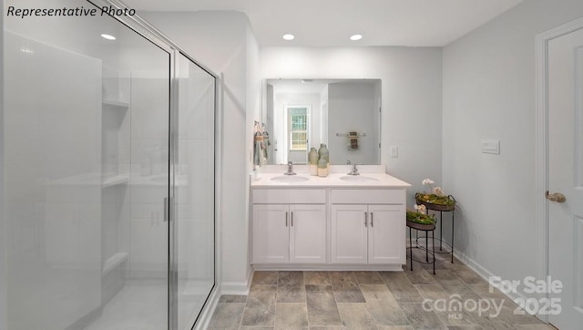 full bath with recessed lighting, double vanity, a sink, and a shower stall