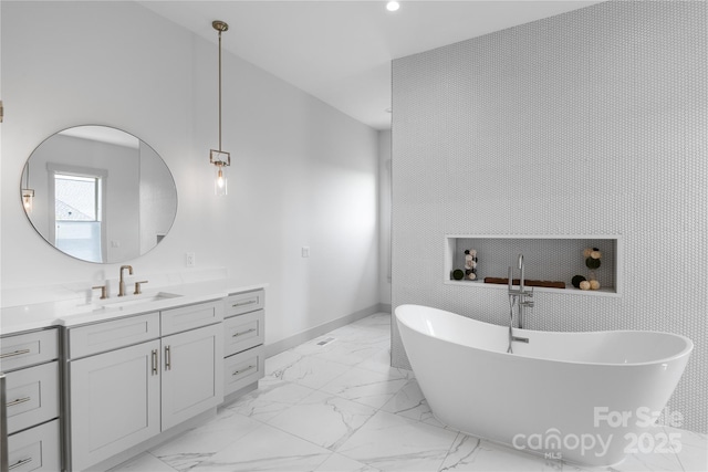 bathroom with baseboards, a soaking tub, marble finish floor, and vanity