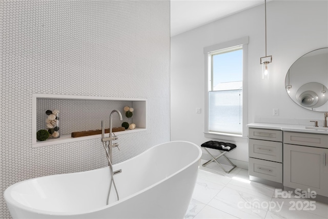 full bath with a soaking tub, marble finish floor, and vanity