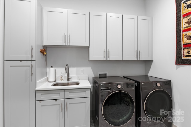 clothes washing area featuring cabinet space, independent washer and dryer, and a sink