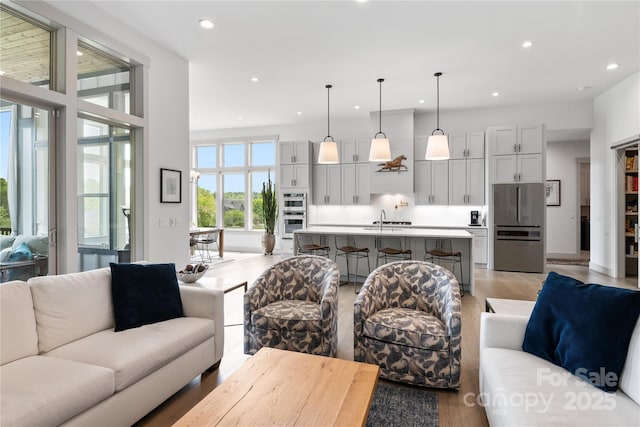living room with recessed lighting and light wood-style flooring