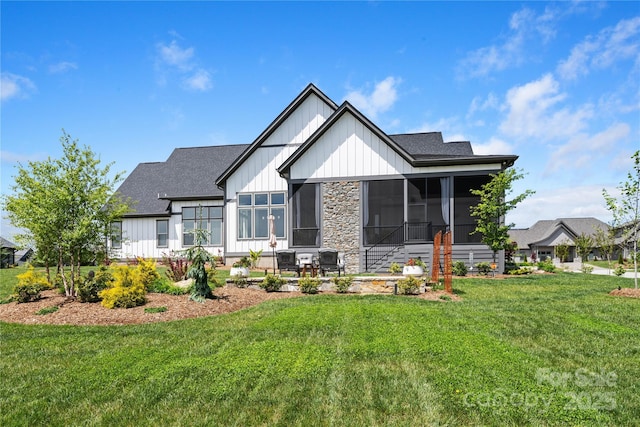view of front of property with board and batten siding, roof with shingles, and a front yard