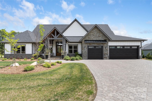 craftsman house featuring decorative driveway, a garage, board and batten siding, and stone siding