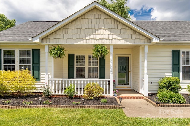 view of front of property with covered porch and a shingled roof