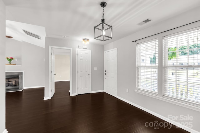 interior space with a fireplace with raised hearth, baseboards, and visible vents