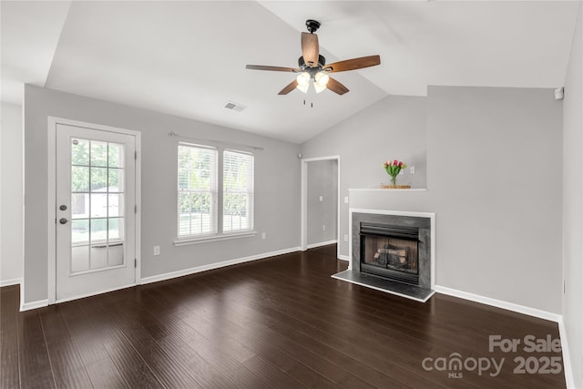 unfurnished living room with wood finished floors, a ceiling fan, a fireplace, visible vents, and vaulted ceiling