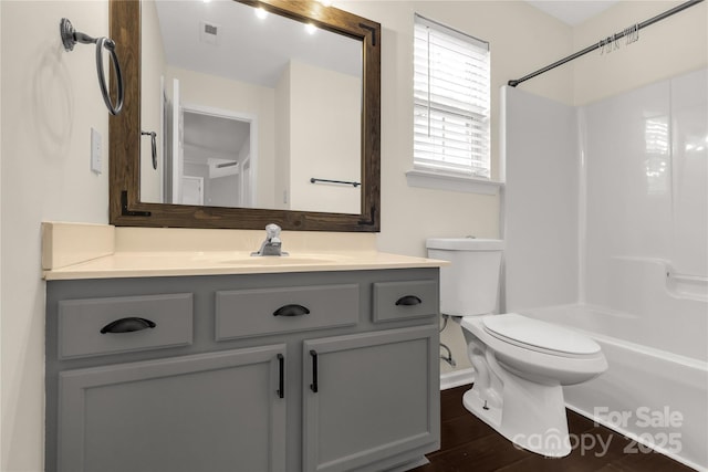full bathroom with toilet, wood finished floors, vanity, visible vents, and baseboards