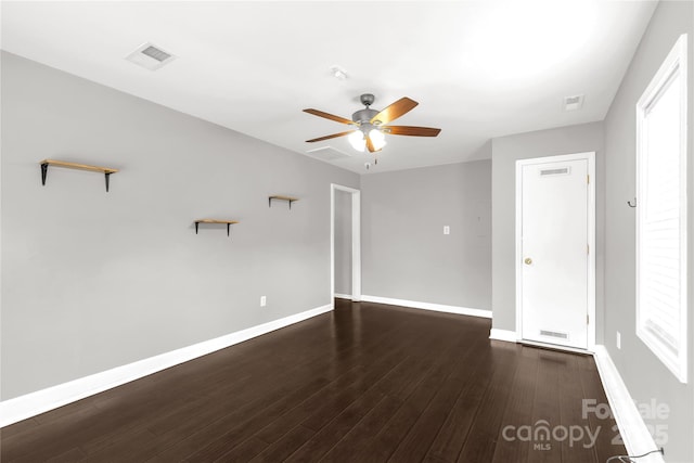 spare room featuring visible vents, wood finished floors, baseboards, and ceiling fan