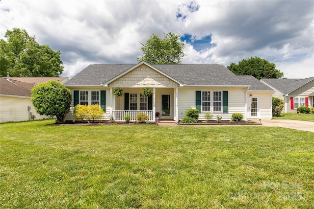 ranch-style home featuring a porch, a front yard, and a shingled roof