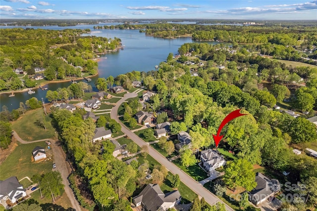 bird's eye view with a water view, a view of trees, and a residential view