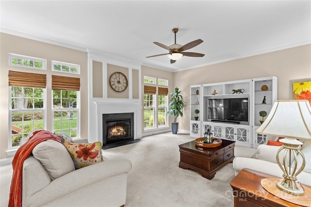 carpeted living area featuring a fireplace with flush hearth, ornamental molding, baseboards, and ceiling fan