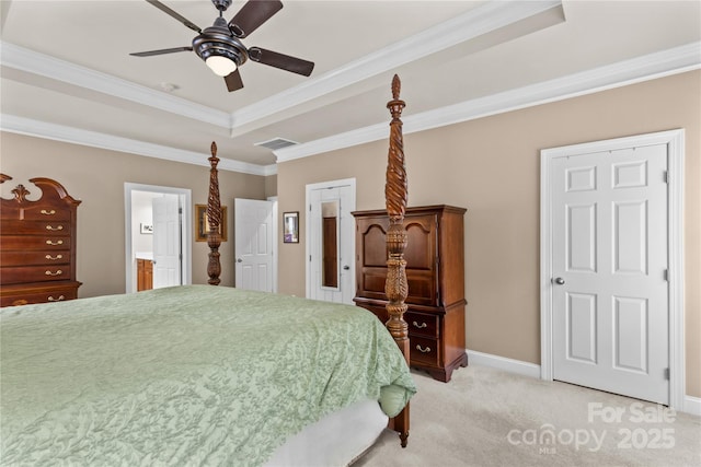 bedroom with connected bathroom, a tray ceiling, crown molding, visible vents, and light carpet