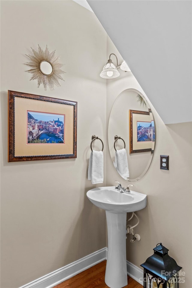 bathroom featuring a sink, baseboards, and wood finished floors