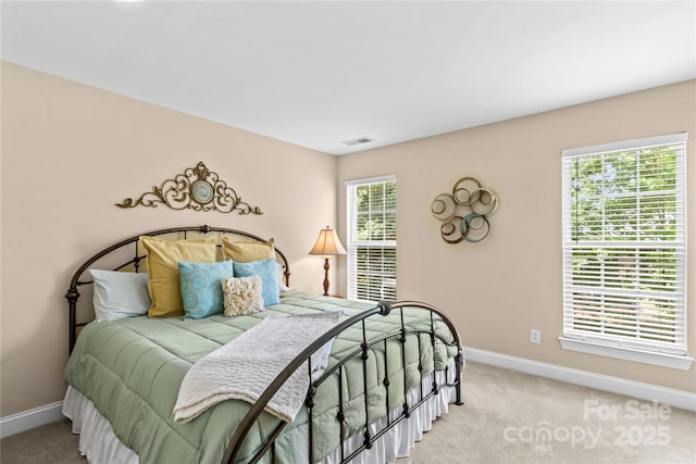 bedroom featuring baseboards, light carpet, and visible vents
