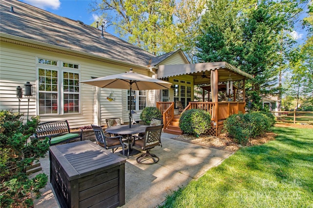 view of patio featuring a ceiling fan, a deck, and outdoor dining space