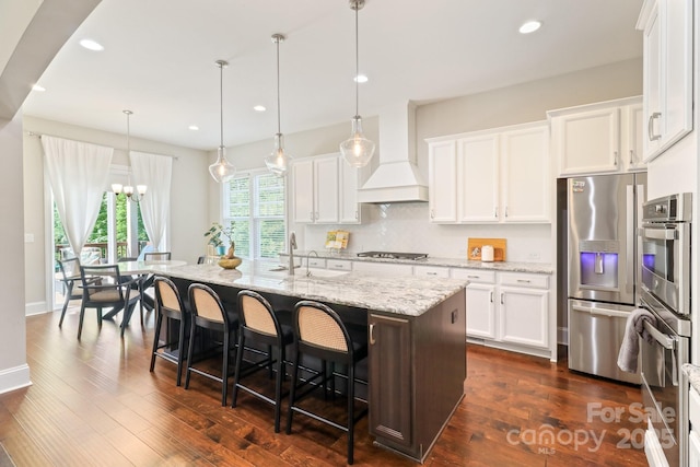 1004 Princesa Dr, Matthews, NC 28104 - kitchen with an inviting chandelier, custom exhaust hood, a kitchen bar, a sink, and stainless steel appliances
