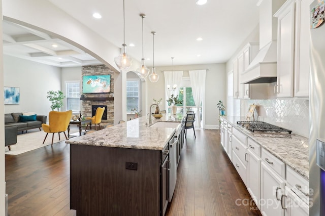 1004 Princesa Dr, Matthews, NC 28104 - kitchen with a sink, white cabinetry, recessed lighting, a fireplace, and arched walkways