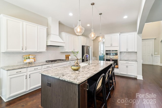 1004 Princesa Dr, Matthews, NC 28104 - kitchen featuring decorative backsplash, custom exhaust hood, white cabinets, a sink, and appliances with stainless steel finishes