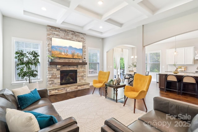 1004 Princesa Dr, Matthews, NC 28104 - living area featuring a fireplace, arched walkways, recessed lighting, wood finished floors, and coffered ceiling