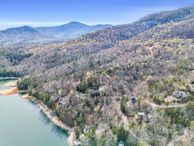 drone / aerial view featuring a water and mountain view and a forest view