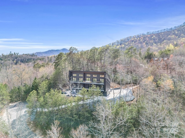 birds eye view of property featuring a wooded view and a mountain view