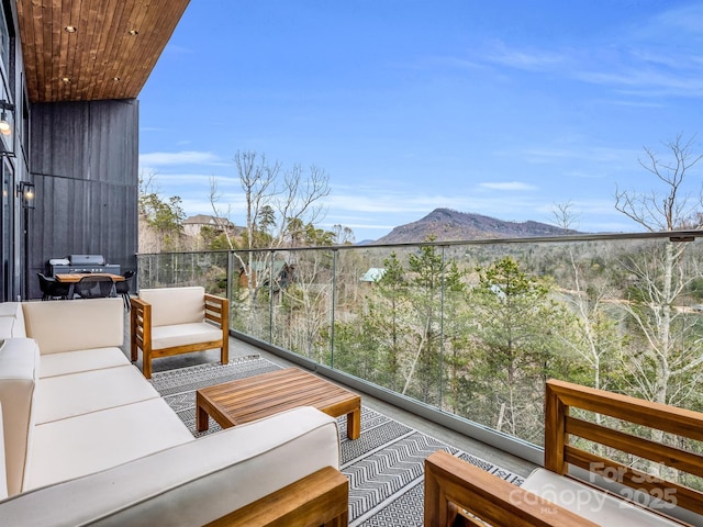 balcony featuring a mountain view and an outdoor hangout area