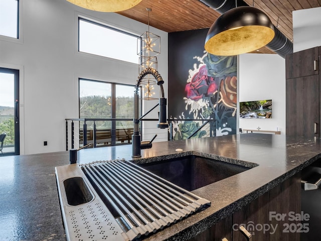 kitchen with plenty of natural light, dark countertops, a chandelier, and wooden ceiling