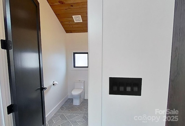 bathroom featuring toilet, tile patterned floors, baseboards, wooden ceiling, and lofted ceiling