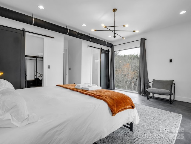 bedroom with an inviting chandelier, finished concrete flooring, recessed lighting, and a barn door
