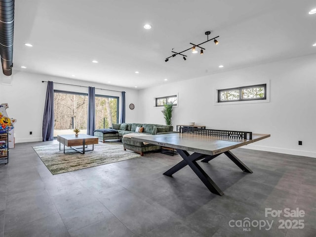 recreation room with baseboards, recessed lighting, and concrete floors
