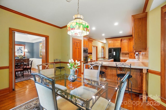 3804 Bellingham Ln, Charlotte, NC 28215 - dining space featuring light wood-style floors, ornamental molding, recessed lighting, and baseboards