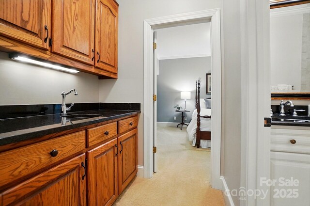 3804 Bellingham Ln, Charlotte, NC 28215 - kitchen with light colored carpet, a sink, and brown cabinets