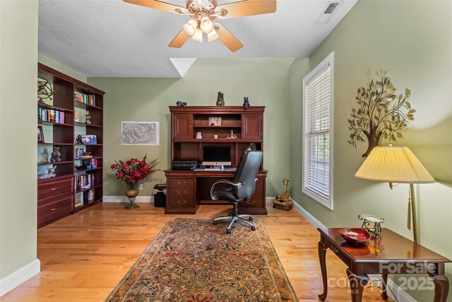 home office featuring ceiling fan, visible vents, baseboards, and light wood-type flooring