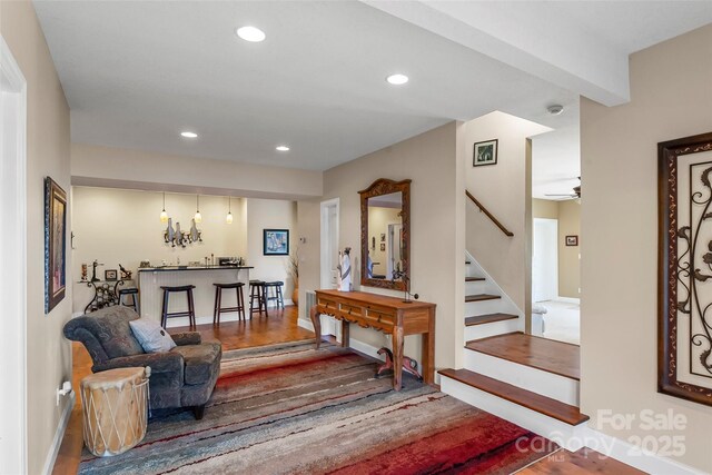living room featuring stairs, wood finished floors, baseboards, ceiling fan, and recessed lighting