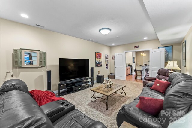 living area featuring carpet flooring, recessed lighting, baseboards, and visible vents