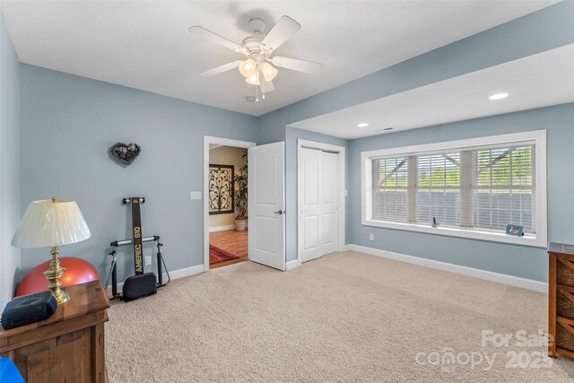interior space featuring baseboards, ceiling fan, and carpet flooring