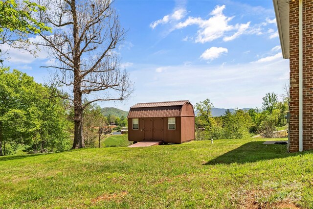 view of yard featuring a mountain view, an outbuilding, and a shed