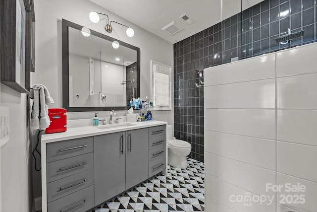 1550 High St, Charlotte, NC 28211 - bathroom with visible vents, tile walls, a walk in shower, vanity, and toilet