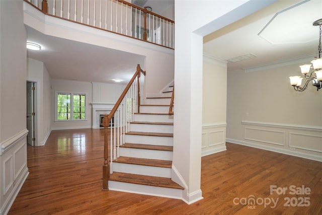 4410 Laurel Twig Ct, Charlotte, NC 28215 - stairs with crown molding, a decorative wall, and wood finished floors