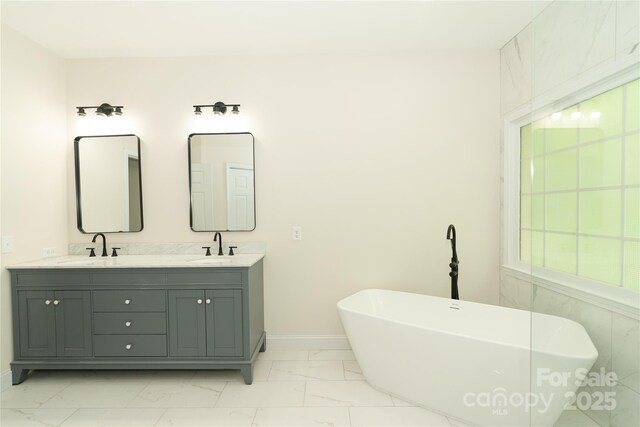 4410 Laurel Twig Ct, Charlotte, NC 28215 - bathroom featuring a soaking tub, a sink, double vanity, baseboards, and marble finish floor