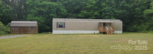 544 Bentley Rd, Shelby, NC 28152 - rear view of property with a lawn, a view of trees, an outdoor structure, and a storage unit