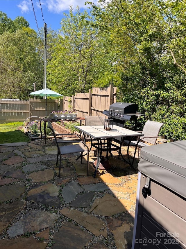 view of patio featuring fence, outdoor dining space, and area for grilling