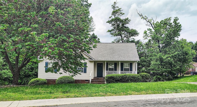 view of front of property featuring covered porch, a shingled roof, and a front yard