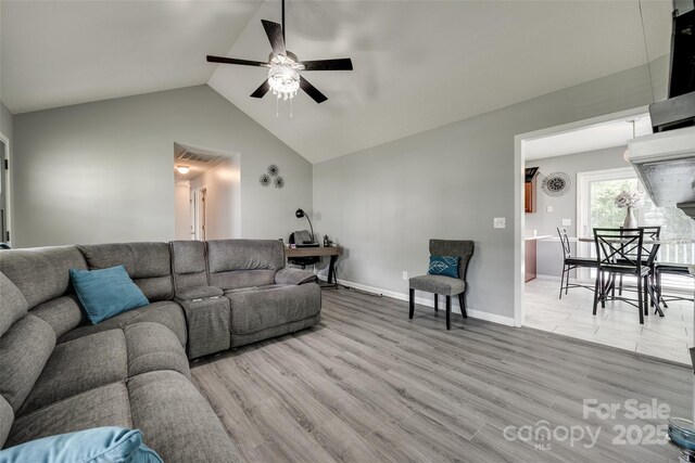 living room with a ceiling fan, baseboards, wood finished floors, and vaulted ceiling