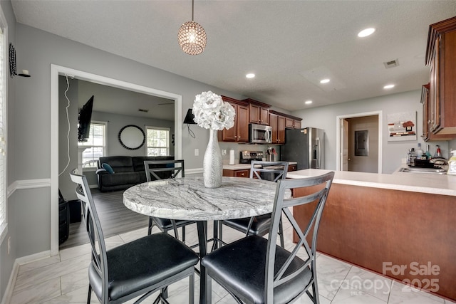 dining space with a textured ceiling, visible vents, baseboards, marble finish floor, and recessed lighting