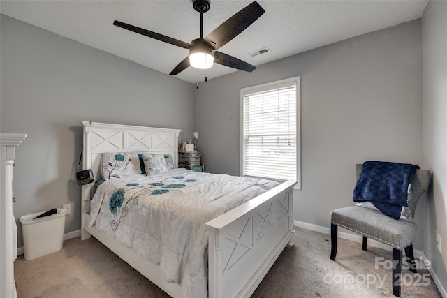 bedroom with light colored carpet, a textured ceiling, baseboards, and visible vents
