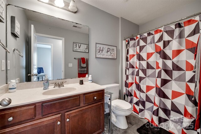 bathroom featuring toilet, a shower with curtain, vanity, a textured ceiling, and visible vents